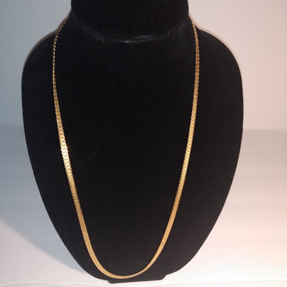 Long gold tone design necklace.